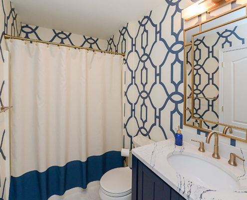 hall bathroom with eclectic wallpaper and white and blue shower curtain