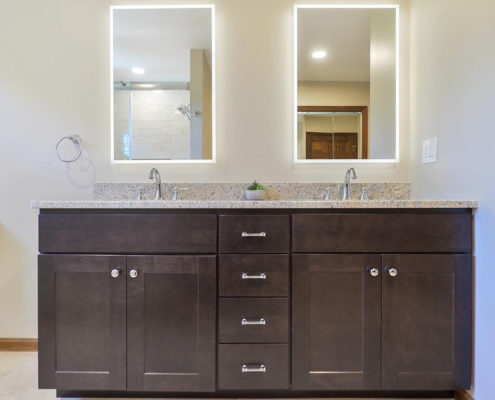 neutral master bathroom double vanity with backlit mirrors
