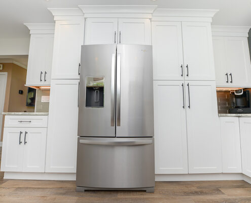 Sleek kitchen remodel, chrome refrigerator, white cabinets