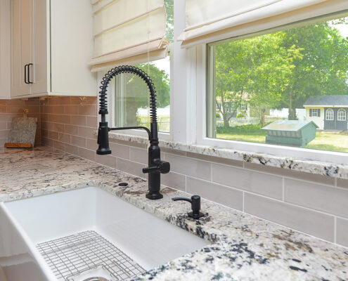 Kitchen model, white cabinets, marble counters, natural lighting, sink