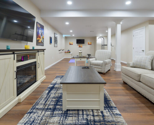 Basement remodel, white walls, movie posters, couch, television, exercise equipment