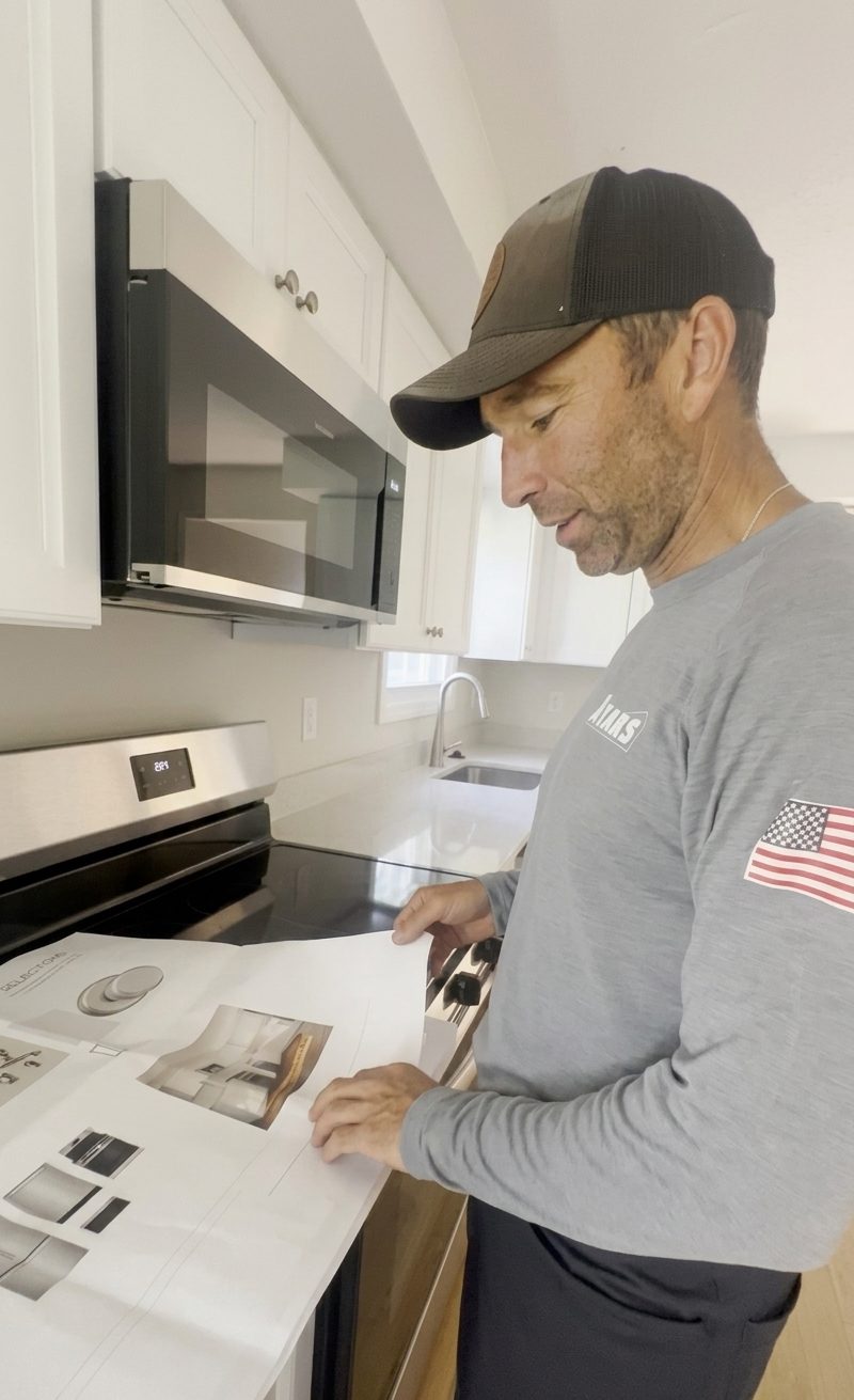 Ayars carpenter reviewing manufacturer installation instructions in a new kitchen